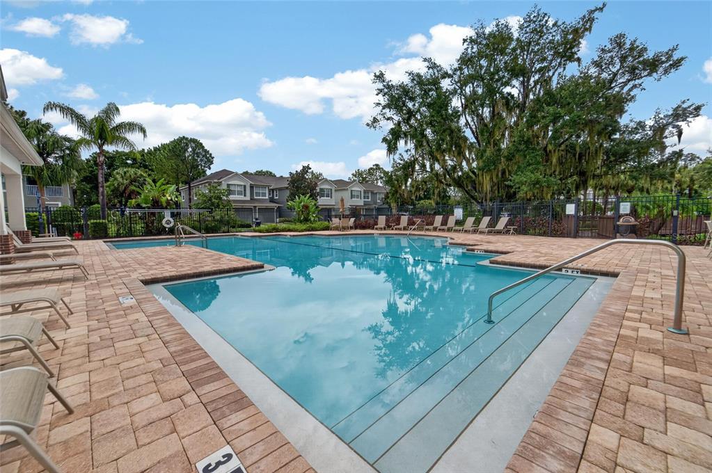 A swimming pool with a paved deck and lounge chairs surrounded by trees and buildings — 2005 RIVER TURIA CIRCLE, RIVERVIEW, FL