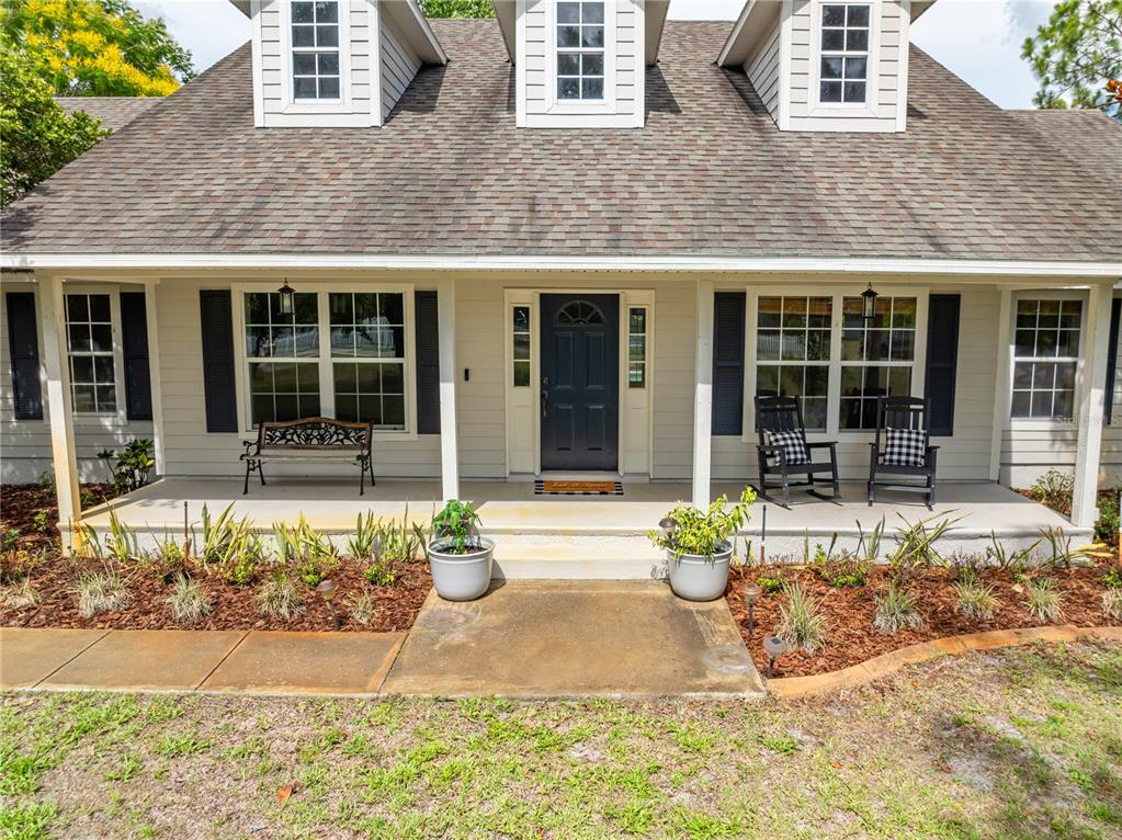 A single-story house with a covered front porch, three dormer windows, and a dark door — 2065 MUSTANG COURT, ST CLOUD, FL