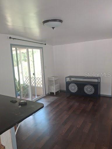 A room with dark wood flooring, white walls, a ceiling light, and sliding glass doors — 9723 TOM STREET, HUDSON, FL