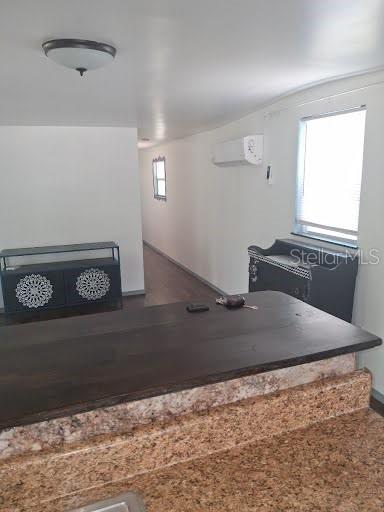 A kitchen counter with granite surfaces overlooks a living area with a dark storage cabinet — 9723 TOM STREET, HUDSON, FL
