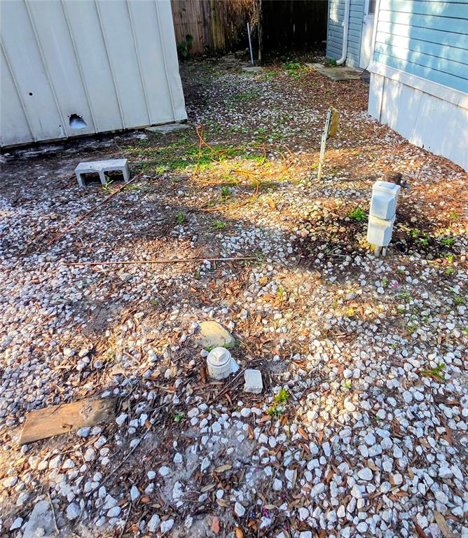 An exterior view of a gravel yard with utility pipes, a concrete block, and buildings — 3000 CLARCONA ROAD UNIT 244, APOPKA, FL