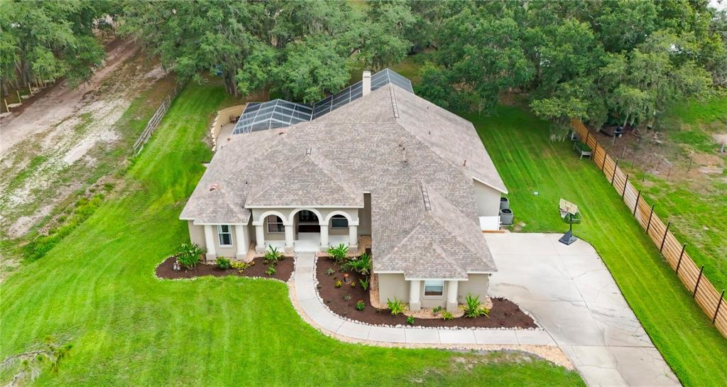 An aerial view of a single-story house with a screened-in pool and a concrete driveway — 13020 SHADOW RUN BOULEVARD, RIVERVIEW, FL
