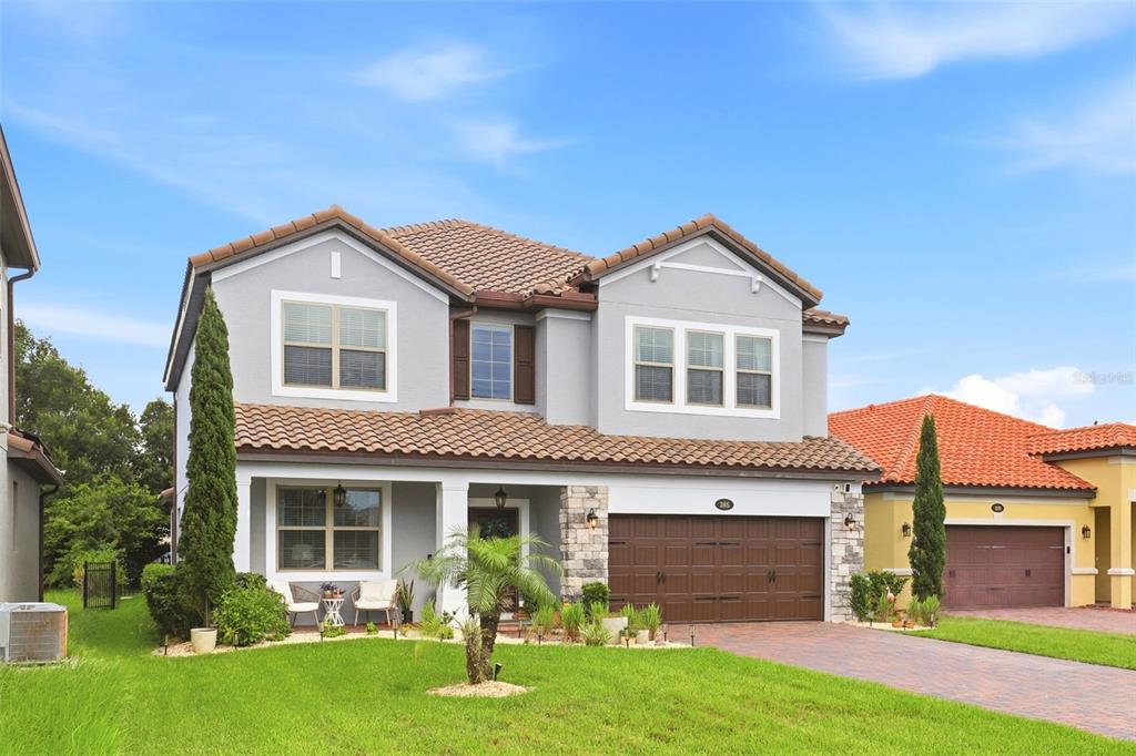 The exterior of a two-story house features a brown garage door, front door, and porch — 285 ANCONA AVENUE, DEBARY, FL
