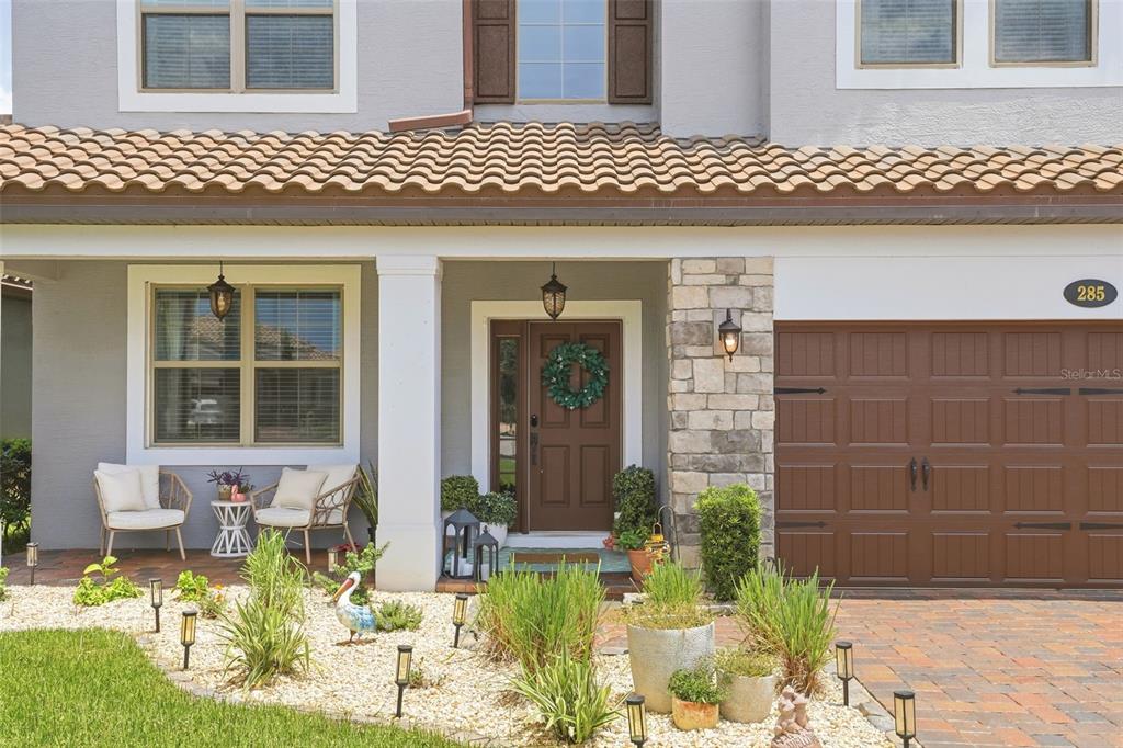 A bright, open-concept living area features wood-look tile flooring, exposed ceiling beams, and arched entryways — 285 ANCONA AVENUE, DEBARY, FL