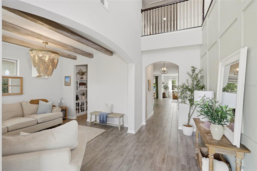A living room features a beige sofa, an armchair, wooden ceiling beams, and a chandelier — 285 ANCONA AVENUE, DEBARY, FL