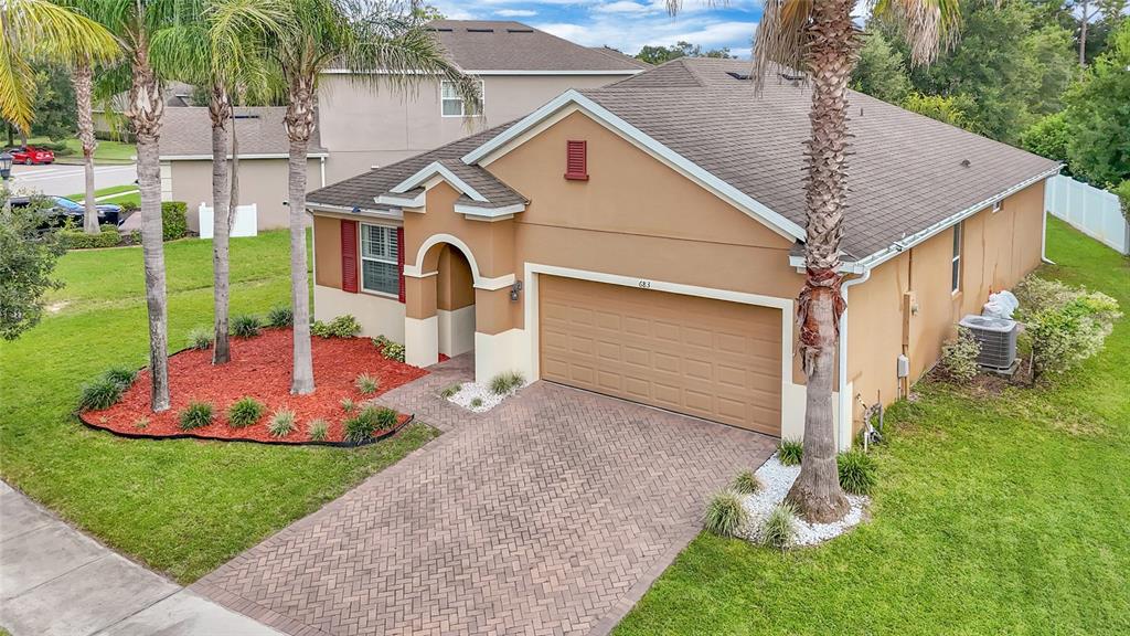 An aerial view of a single-story tan house with a brick driveway and palm trees — 683 CHAMPIONS GATE BOULEVARD, DELAND, FL