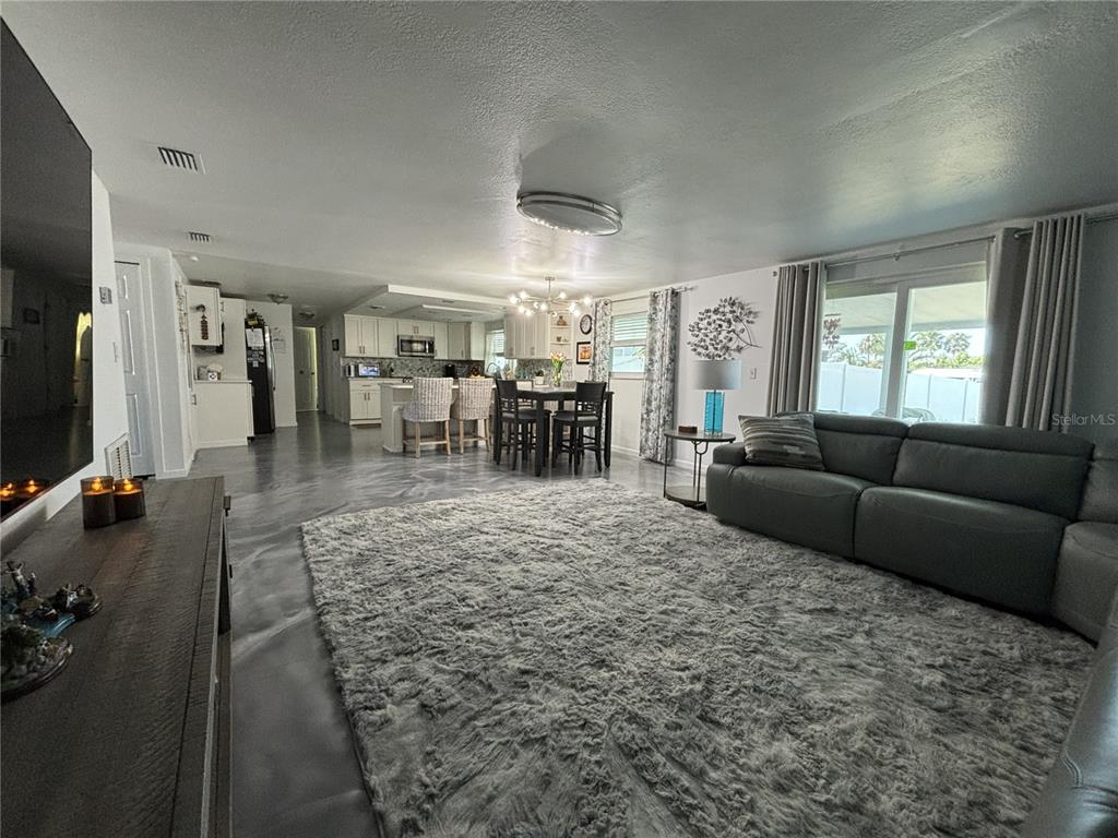 A dining area and kitchen with white cabinets, a central island, and gray flooring — 1002 SILVER PALM WAY, APOLLO BEACH, FL