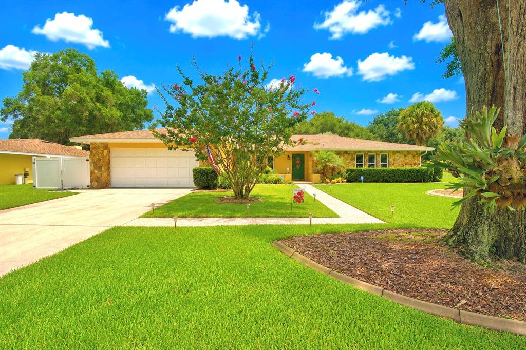 A single-story house with a lawn, a large tree, and a paved walkway — 902 CRESTVIEW DRIVE, AUBURNDALE, FL