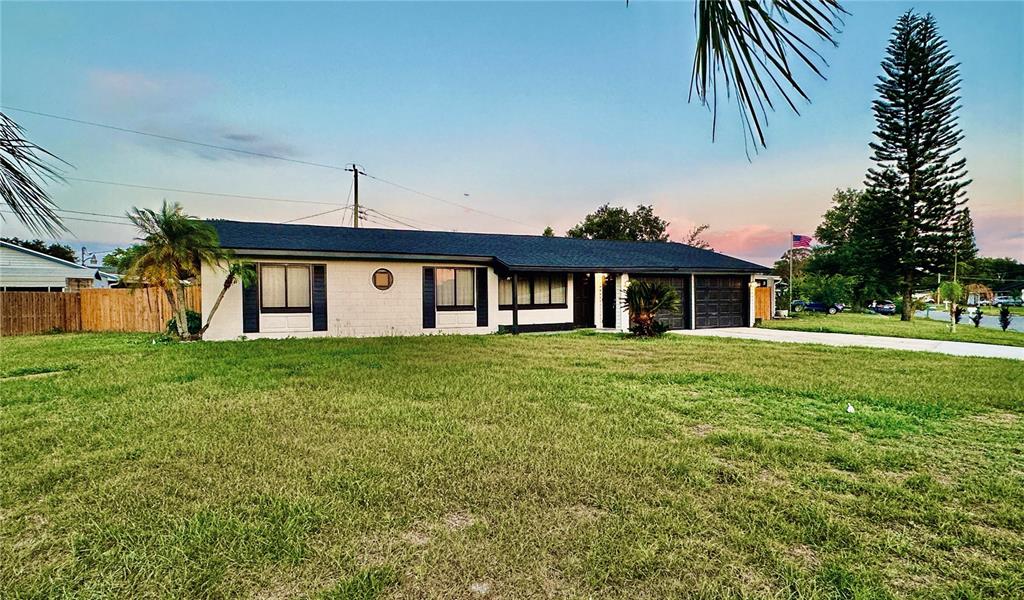 A single-story house with a dark roof, white exterior, and an attached two-car garage — 1886 CLEMATIS LANE, WINTER PARK, FL