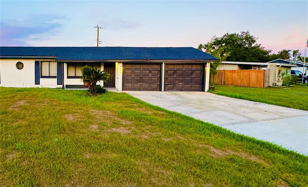 A single-story house with a dark roof, white siding, and a two-car garage — 1886 CLEMATIS LANE, WINTER PARK, FL