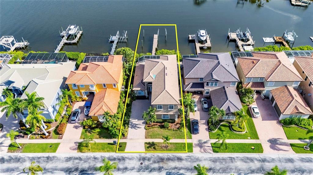 An aerial view shows a waterfront house with a private dock and a paved driveway — 1231 ACAPPELLA LANE, APOLLO BEACH, FL