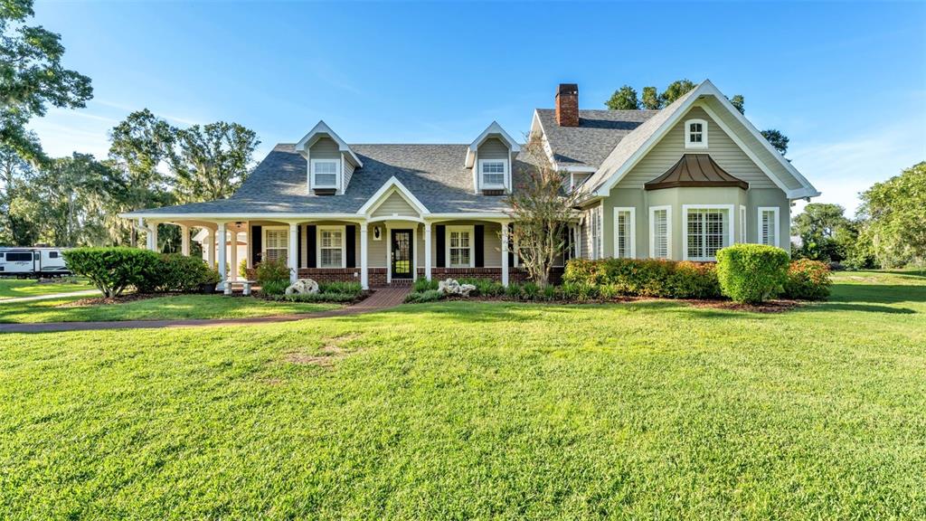 A two-story house with a wrap-around porch, dormer windows, and a large front lawn — 4233 HOMEWOOD LANE, LAKELAND, FL