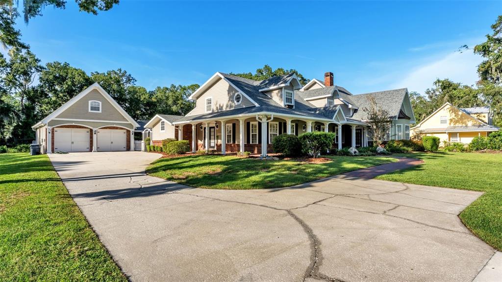 A large two-story house with a detached garage and a cracked concrete driveway — 4233 HOMEWOOD LANE, LAKELAND, FL
