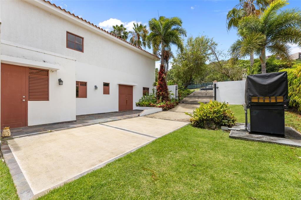 A white house exterior features a concrete driveway, a lawn, and a black covered grill — Las Vistas 36,  Rio Mar MIRADOR, 36, RIO MAR, RIO GRANDE, PR