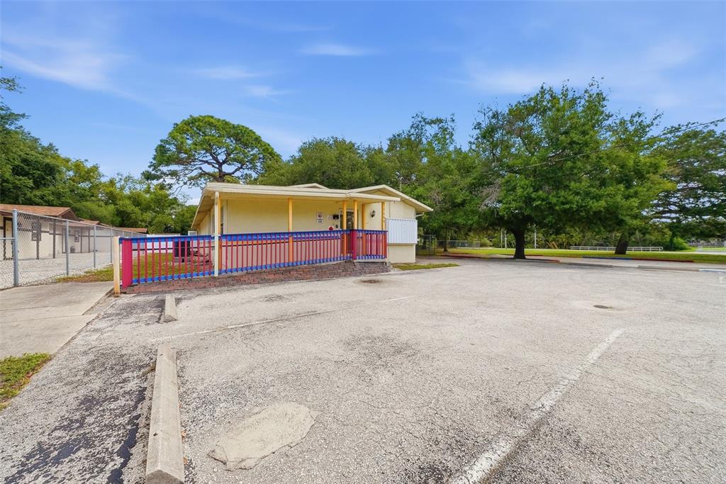 A single-story building with a ramp and colorful railing sits next to a parking lot — 2886 WHITNEY ROAD, CLEARWATER, FL
