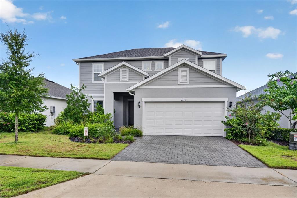 A two-story gray house features a two-car garage and a paved driveway — 2340 SIRENA LANE, MOUNT DORA, FL
