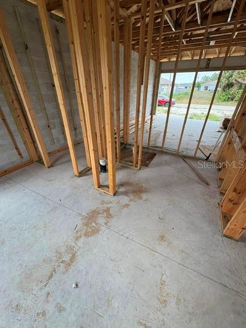 An unfinished room with exposed wood wall studs and a concrete floor under construction — 3505 39TH STREET SW, LEHIGH ACRES, FL