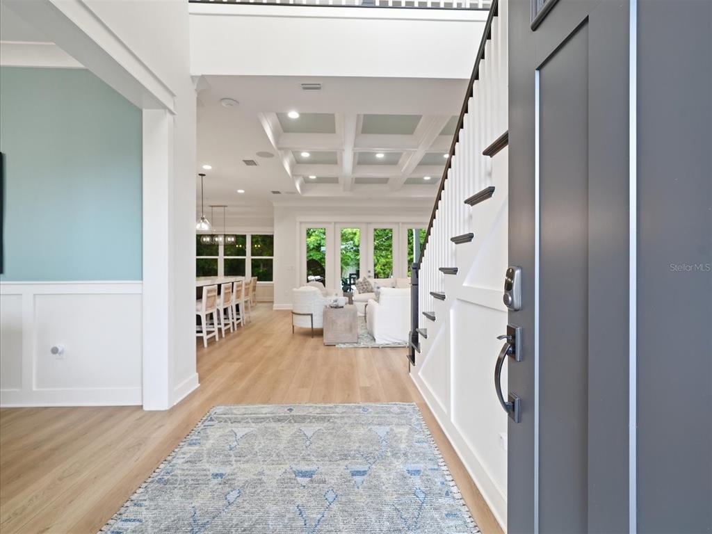 A view from an entryway into a bright, open-concept living area with coffered ceilings — 3718 W PALMIRA AVENUE, TAMPA, FL