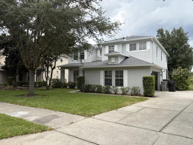 A two-story light gray house with a front porch, lawn, and concrete driveway — 1885 SCRUB JAY RD., APOPKA, FL