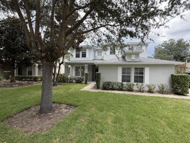 A two-story house with a light gray exterior, a large tree, and a manicured lawn — 1885 SCRUB JAY RD., APOPKA, FL