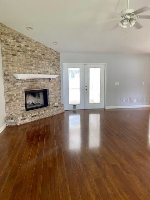 A living room features a brick fireplace, hardwood floors, and a ceiling fan — 1258 NE 51ST LOOP, OCALA, FL