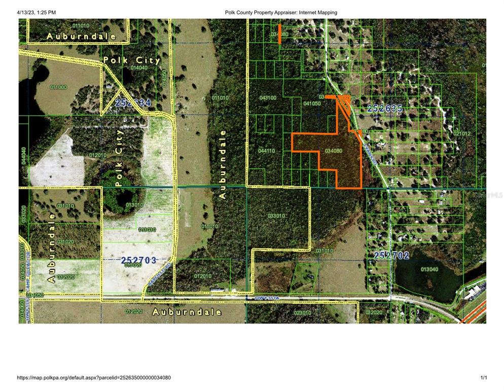 This is a Google Maps satellite view showing a road bordered by rural land and buildings — EVANS RD, POLK CITY, FL
