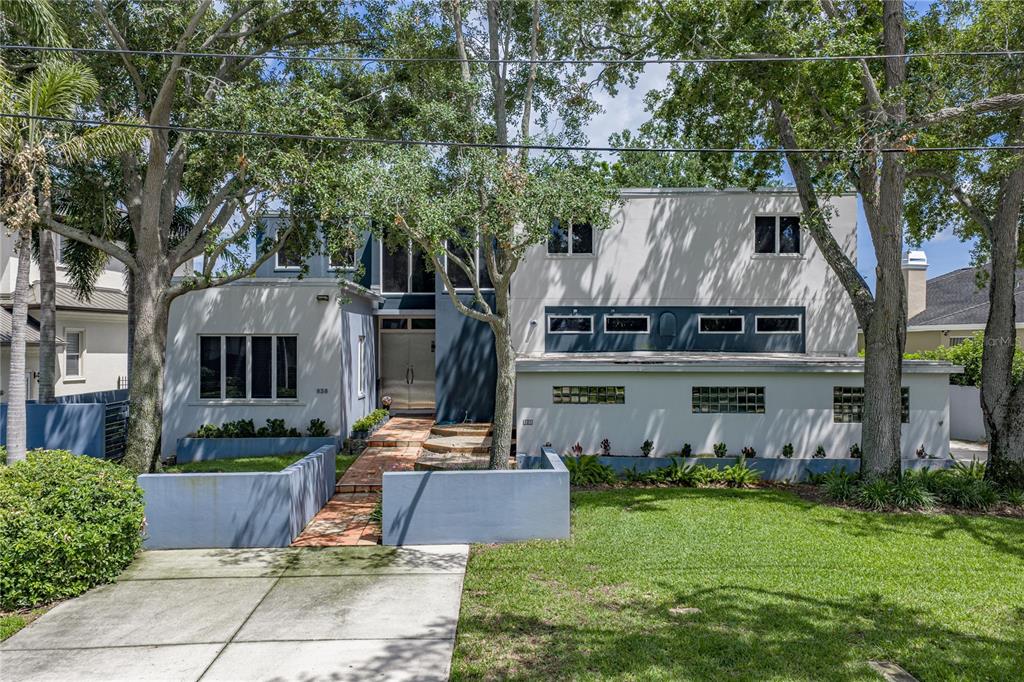 The rear exterior of a two-story blue house features a patio, balcony, and large lawn — 838 MONTEREY BOULEVARD NE, ST PETERSBURG, FL