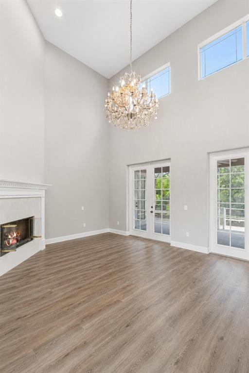 A bright living room features a fireplace, a large chandelier, and glass doors to a patio — 10370 TROUT ROAD, ORLANDO, FL