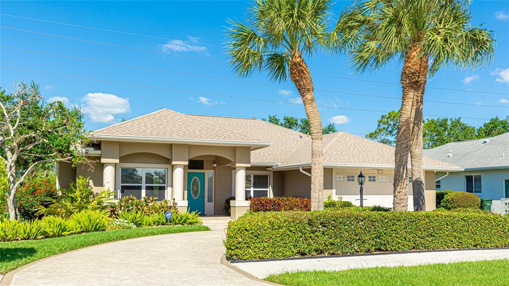A single-story house with a beige exterior, a teal front door, and two tall palm trees — 534 OAK BAY DRIVE, OSPREY, FL