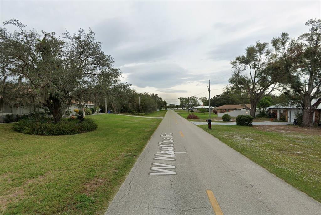 A paved residential street named W Nautilus Rd is lined with trees and houses — 2479 W NAUTILUS ROAD, AVON PARK, FL