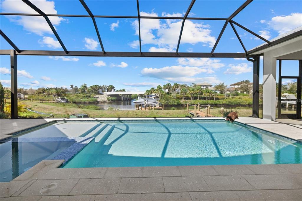 A screened-in pool patio overlooks a canal with a bridge and boat docks — 1831 RIO VISTA TERRACE, PARRISH, FL