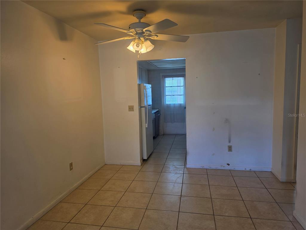 A dining area with tile flooring and a ceiling fan leads into a kitchen — 5850 21ST STREET N UNIT 15, ST PETERSBURG, FL