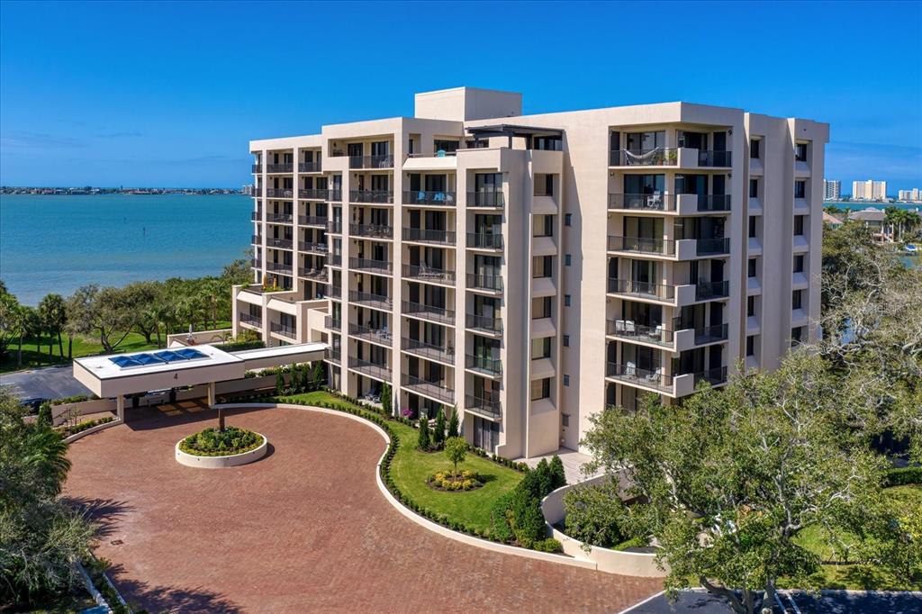 An exterior view of a multi-story apartment building with balconies overlooking a body of water — 4 BELLEVIEW BOULEVARD UNIT 106, BELLEAIR, FL
