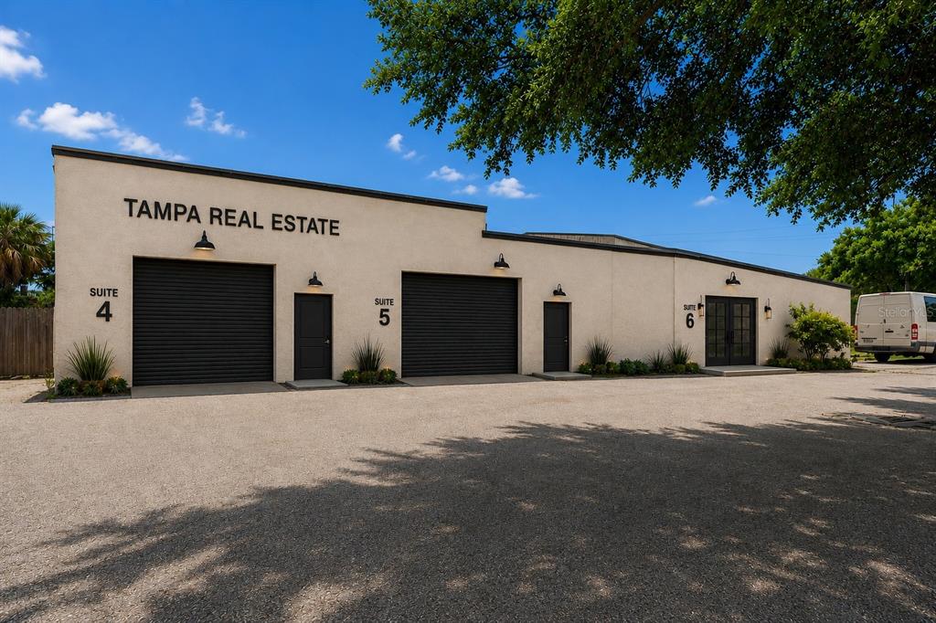 The exterior of a single-story commercial building features three suites with roll-up and glass doors — 4214 W VIRGINIA AVE UNIT 10-A, TAMPA, FL