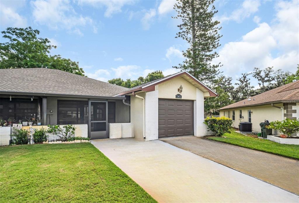 A single-story house with a brown garage door, a screened porch, and a concrete driveway — 3472 MACLAREN DRIVE, PALM HARBOR, FL