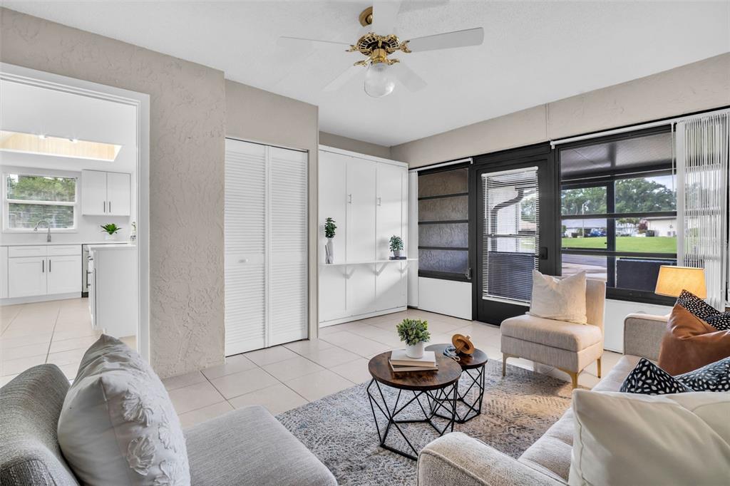 A living room with tile floors, a ceiling fan, and a view of the kitchen — 3472 MACLAREN DRIVE, PALM HARBOR, FL