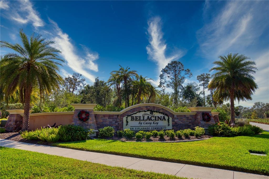 A stone entrance sign for Bellacina by Casey Key sits surrounded by palm trees and landscaping — 5668 CANTUCCI STREET, NOKOMIS, FL