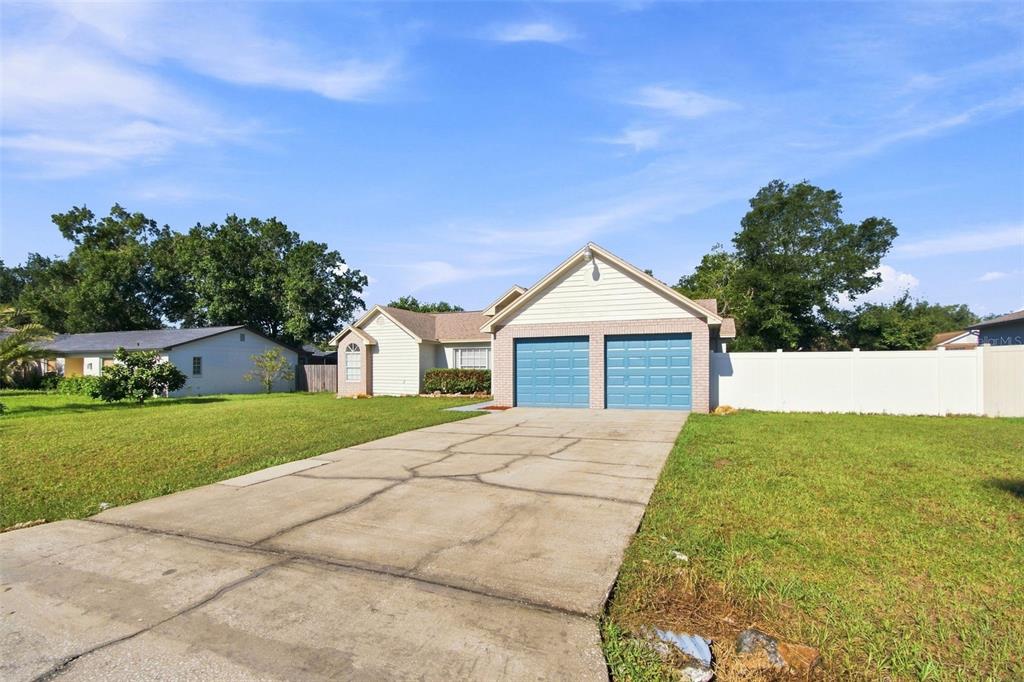 A single-story house with a two-car garage and a large front lawn — 4745 CANTERBURY DRIVE, LAND O LAKES, FL