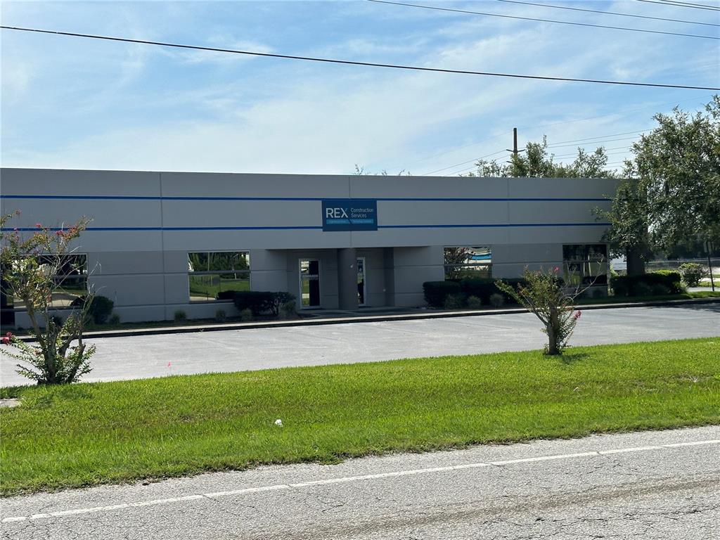 A single-story commercial building with a gray facade and a Rex Construction Services sign — 85 SW 52ND AVENUE, OCALA, FL