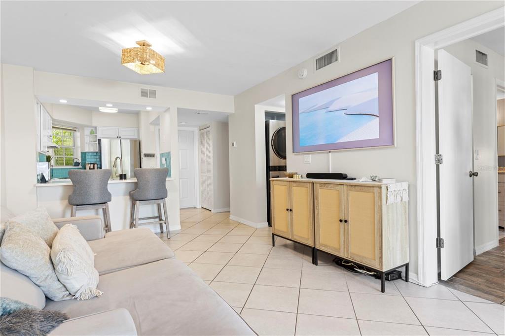 A covered exterior walkway leads to a white front door with a wheat wreath — 6915 STONES THROW CIRCLE N UNIT 3104, ST PETERSBURG, FL
