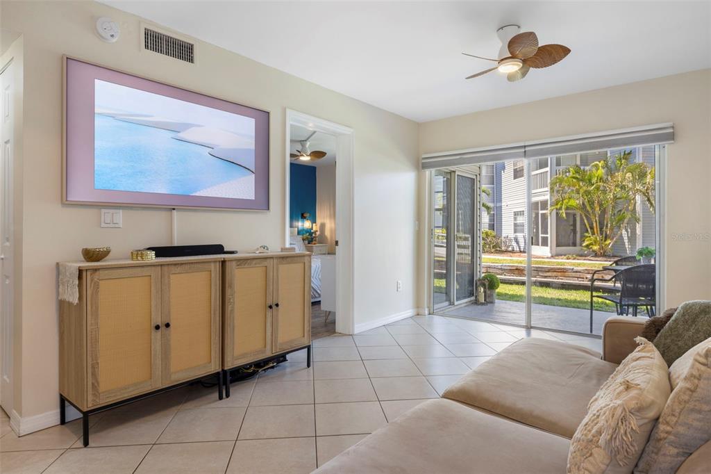 A living room features a light-colored sofa, tile flooring, and a breakfast bar with stools — 6915 STONES THROW CIRCLE N UNIT 3104, ST PETERSBURG, FL