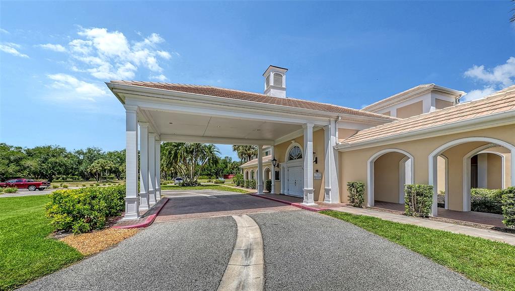 A beige building with a large covered porte-cochère entrance and arched walkways — 51 MACEWEN DRIVE UNIT 12, OSPREY, FL