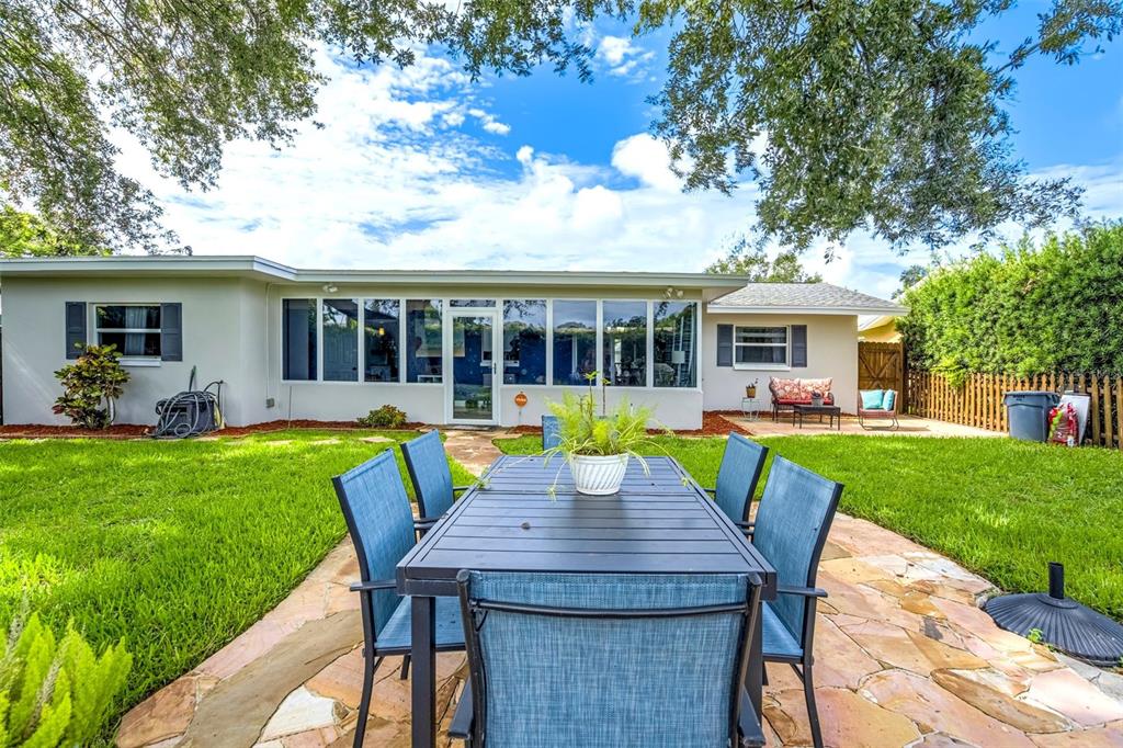 A living room features a brown sofa, two armchairs, nested coffee tables, and hardwood floors — 1636 LEISURE DRIVE, CLEARWATER, FL