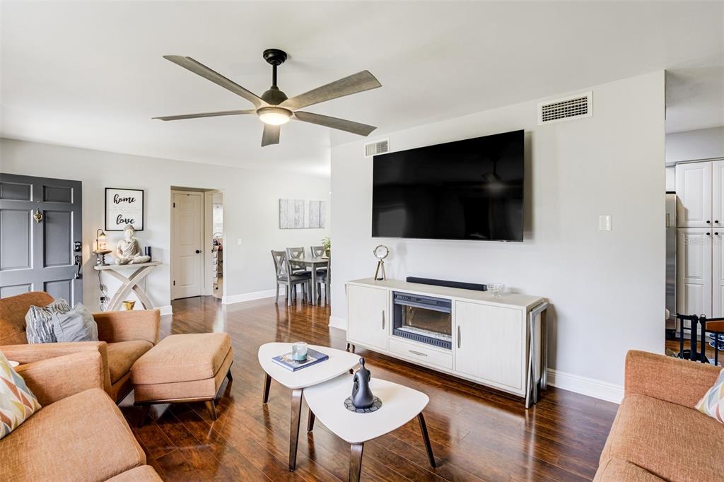 A dining room with a wooden table, six chairs, a chandelier, and a sliding glass door — 1636 LEISURE DRIVE, CLEARWATER, FL