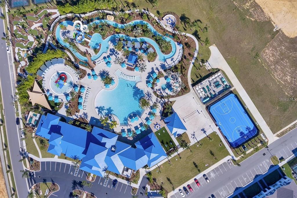 Aerial view of a community amenity center featuring a swimming pool, lazy river, and basketball court — 108 JETTY WAY, DAVENPORT, FL