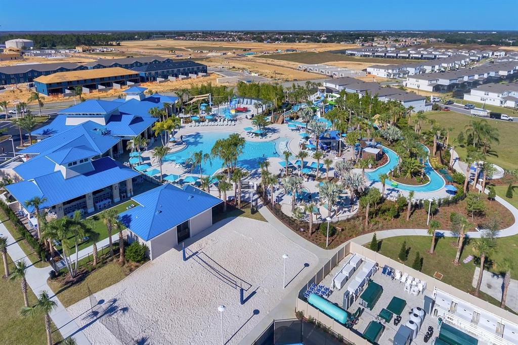 An aerial view shows a community swimming pool complex with a lazy river and clubhouse — 108 JETTY WAY, DAVENPORT, FL