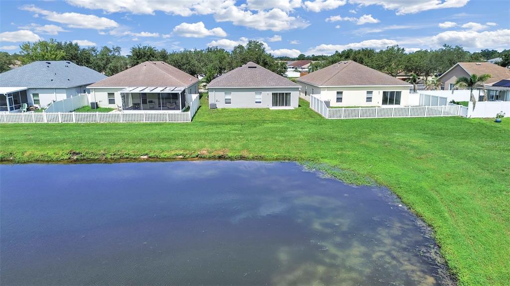 An aerial view of several suburban houses with backyards facing a pond — 11908 FERN BLOSSOM DRIVE, GIBSONTON, FL