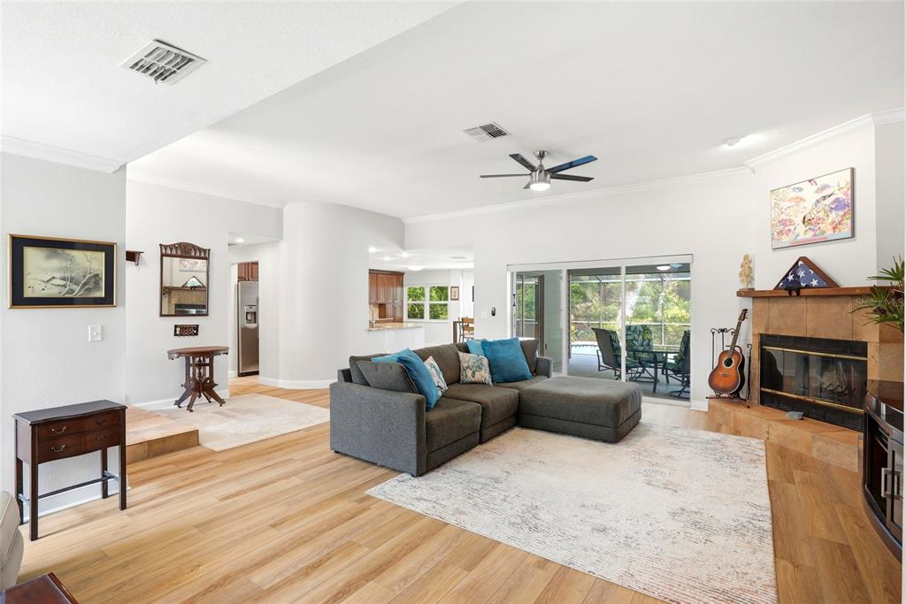 A single-story house with tan siding, a two-car garage, and a landscaped front yard — 4733 LAKE VALENCIA BOULEVARD W, PALM HARBOR, FL