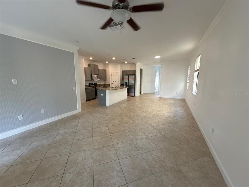 An open-concept living area features tile flooring, a ceiling fan, and a kitchen with island — 950 TERRA VISTA STREET, BRANDON, FL