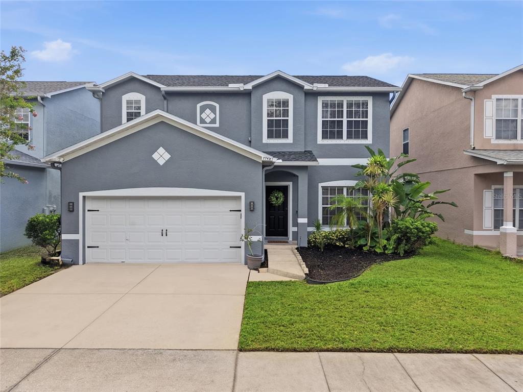 A two-story gray house with a two-car garage and a front lawn — 7749 75TH STREET N, PINELLAS PARK, FL